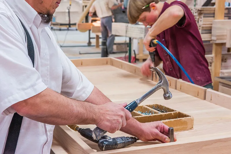 Amish Furniture Craftsman building table by hand