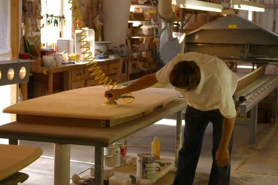 Amish furniture woodworker sanding piece